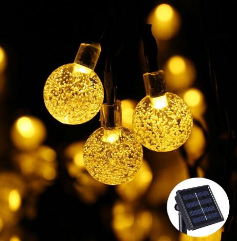 Guirlande solaire LED à boules de cristal allumée sur une terrasse