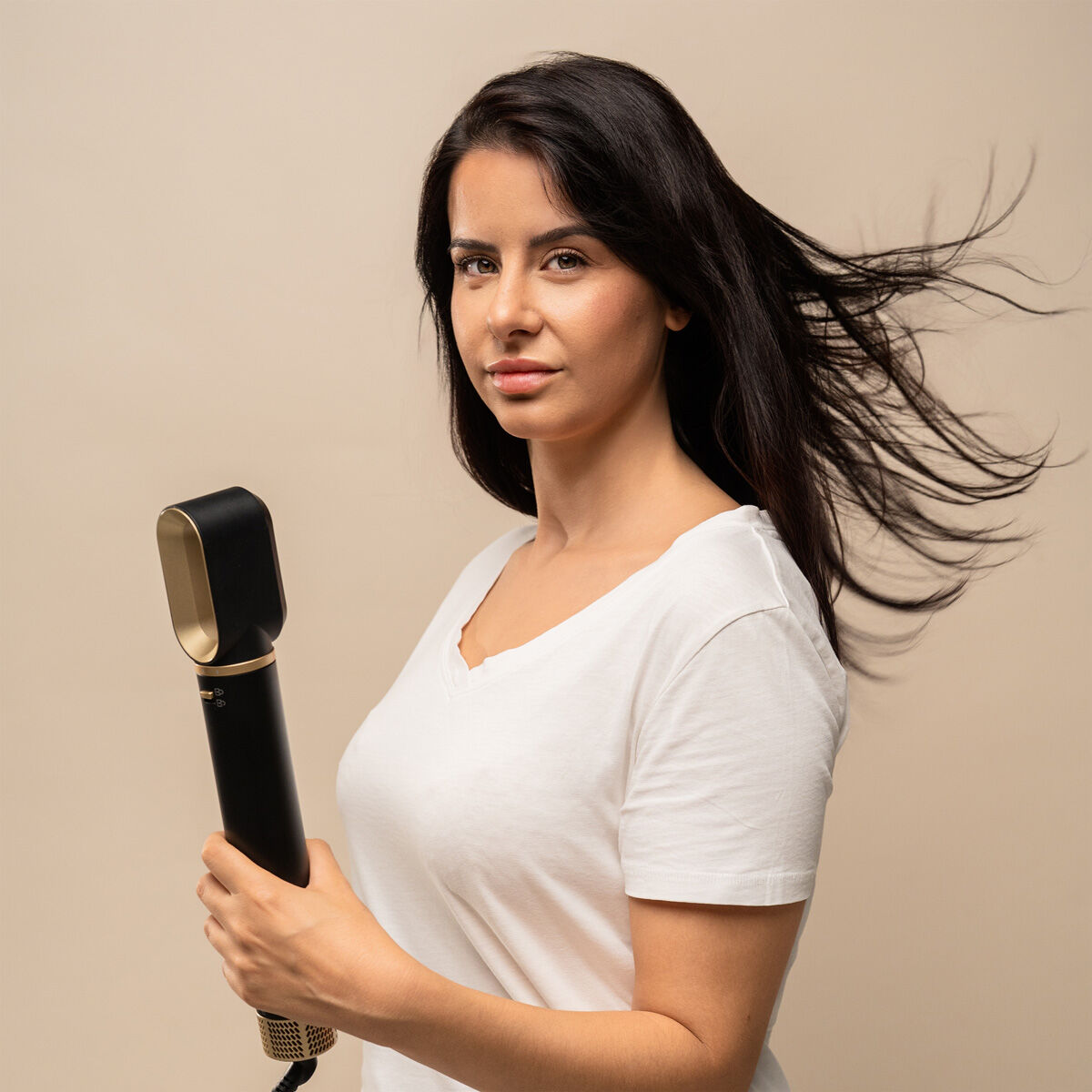 Femme utilisant la brosse soufflante pour coiffer ses cheveux longs